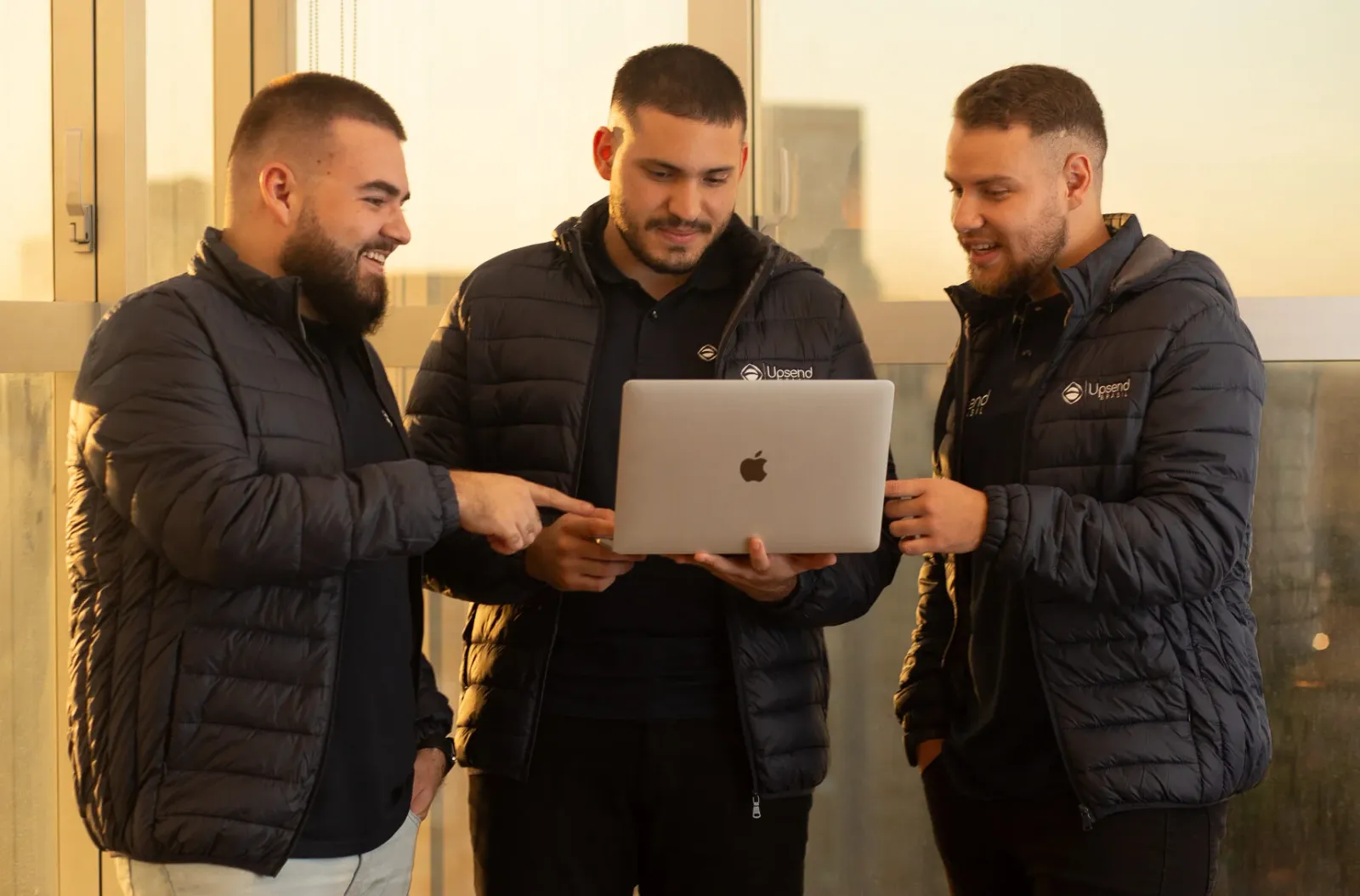 Equipe da Upsend Brasil reunida em volta de um notebook